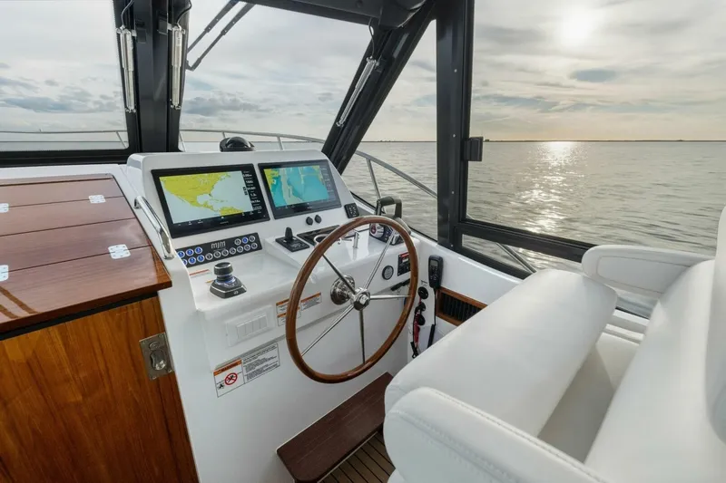 Slide: The Image of Helm of 2025 MJM 42 yacht with navigation screens and wooden steering wheel. - 2