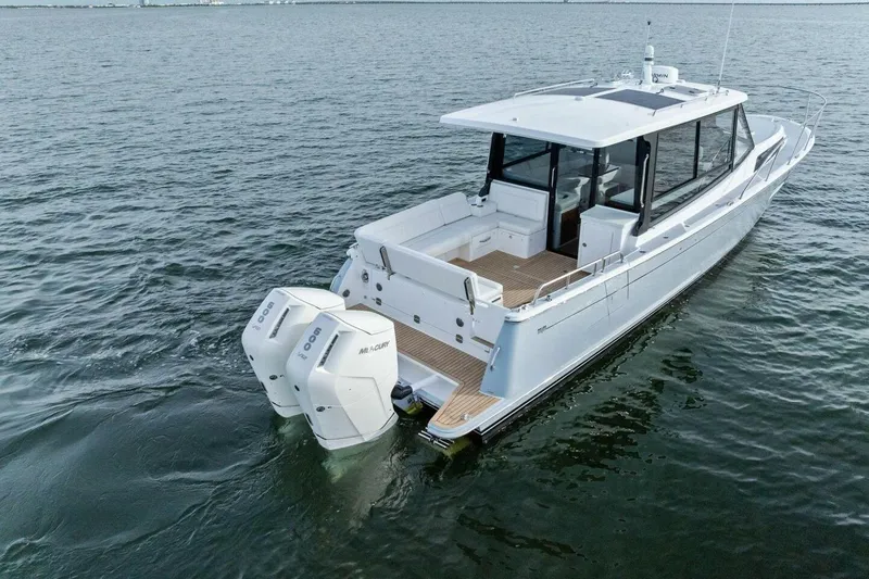 Slide: The Image of 2025 MJM 42 boat with dual outboard engines on calm water. - 36