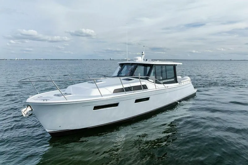 Slide: The Image of 2025 MJM 42 yacht cruising on open water under a cloudy sky. - 37