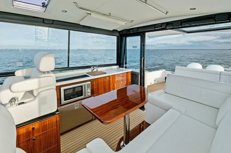 Slide: The Image of Luxurious interior of 2025 MJM 42 yacht with ocean view, featuring elegant seating and kitchenette. - 5