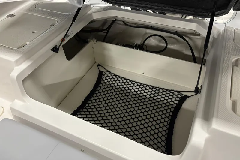 Slide: The Image of 2026 Chaparral 21 SSi OB boat storage compartment with netting and hydraulic lift. - 16