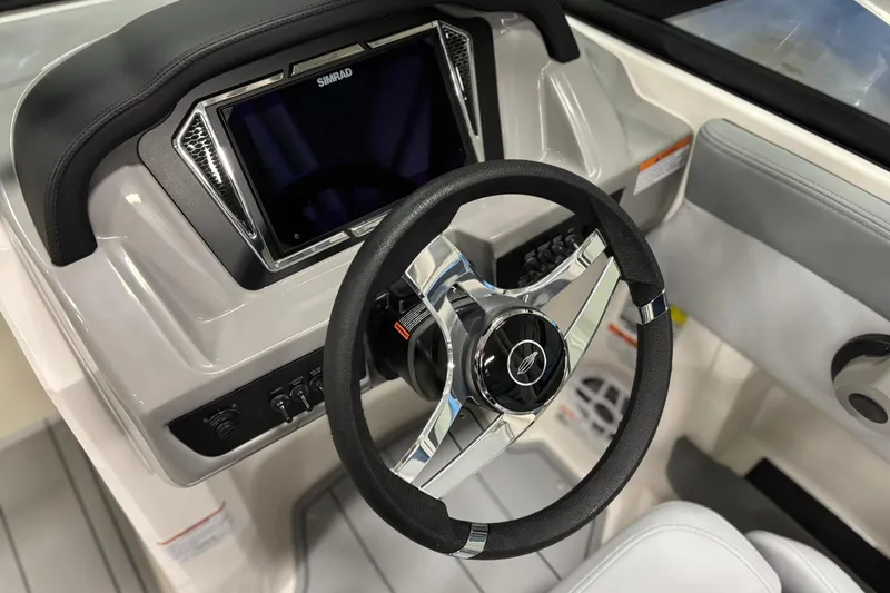 Slide: The Image of 2026 Chaparral 21 SSi OB boat dashboard with steering wheel and Simrad display. - 19