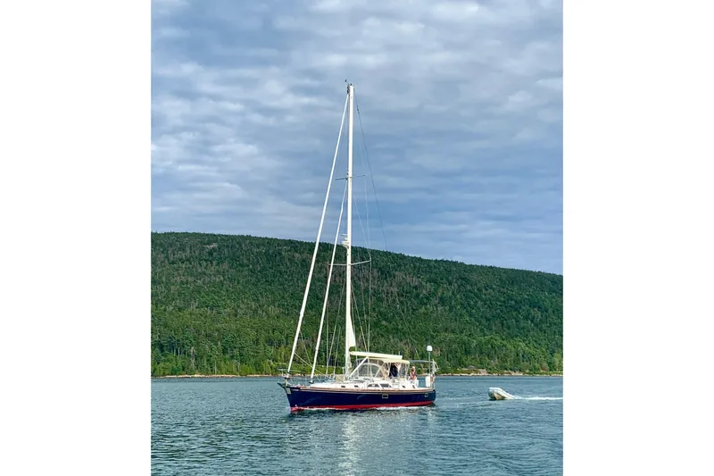 Slide: The Image of Sailing yacht Hylas 46 (2002) cruising on a serene lake with forested hills. - 1