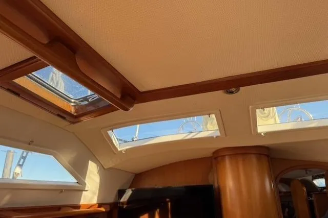 Slide: The Image of Interior view of 2002 Hylas 46 yacht, featuring skylights and wooden finishes. - 26