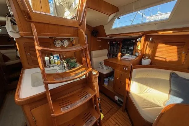 Slide: The Image of Interior of 2002 Hylas 46 yacht with wooden finish and cozy seating area. - 27