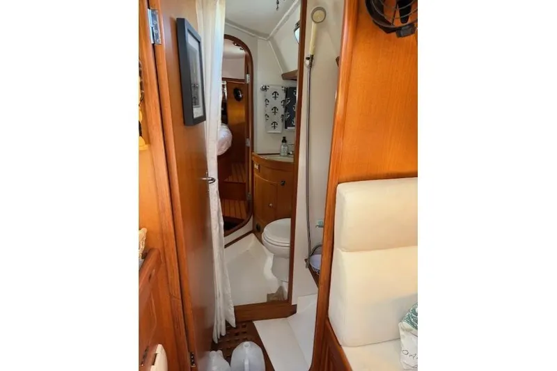 Slide: The Image of Interior of 2002 Hylas 46 yacht featuring a compact bathroom with wooden cabinetry. - 29