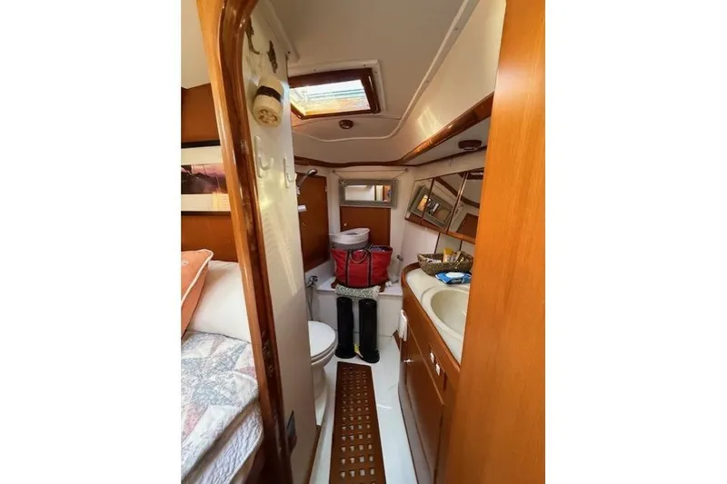 Slide: The Image of Interior of 2002 Hylas 46 yacht bathroom with wooden cabinetry and skylight. - 31