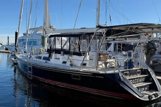 Slide: The Image of 2002 Hylas 46 sailboat docked in marina, featuring sleek design and spacious deck. - 4