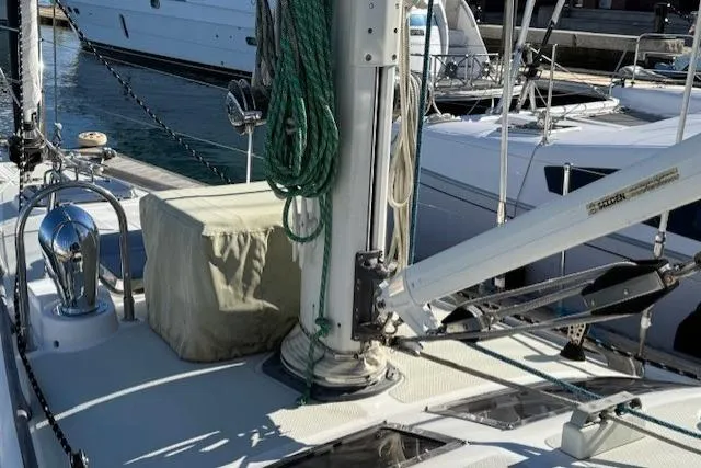 Slide: The Image of 2002 Hylas 46 sailboat deck with mast and winch in marina setting. - 43