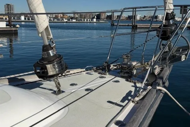 Slide: The Image of Sailboat deck of 2002 Hylas 46, docked in a marina with cityscape background. - 46