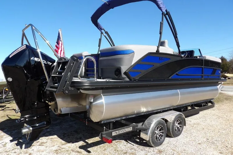 Slide: The Image of 2026 Bennington M Quad Bench 22 MFB pontoon boat on trailer, featuring Mercury engine. - 10