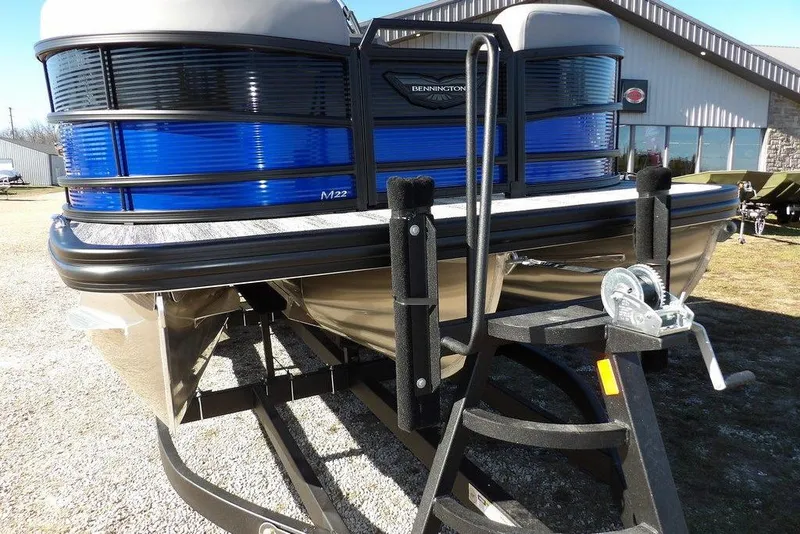 Slide: The Image of 2026 Bennington M Quad Bench 22 MFB pontoon boat on trailer, blue accents. - 43