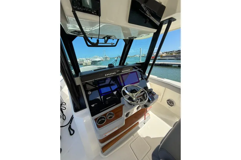 Slide: The Image of 2023 Boston Whaler 360 Outrage helm with advanced navigation system and waterfront view. - 5