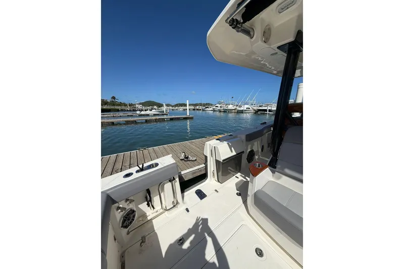 Slide: The Image of 2023 Boston Whaler 360 Outrage docked at marina, showcasing spacious deck and seating. - 7