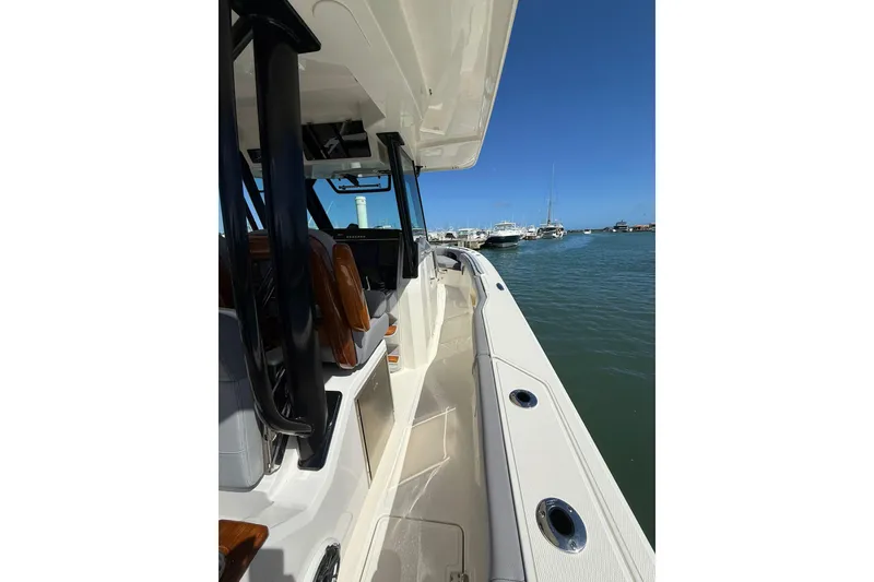 Slide: The Image of 2023 Boston Whaler 360 Outrage boat docked in a marina under clear blue skies. - 8