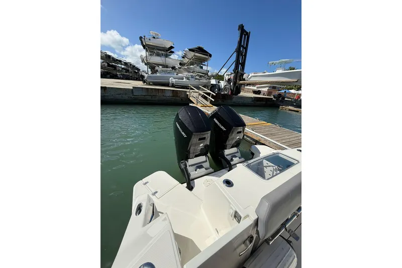 Slide: The Image of 2023 Boston Whaler 360 Outrage with dual Mercury engines at a marina dock. - 9