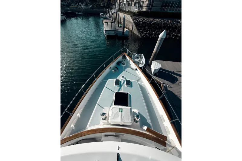 Slide: The Image of 1989 Nordhavn 46 yacht docked at marina, showcasing sleek deck design. - 13
