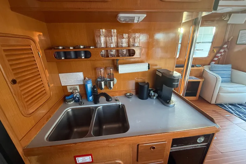 Slide: The Image of 1989 Nordhavn 46 yacht kitchen with wooden cabinetry, dual sink, and coffee maker. - 20
