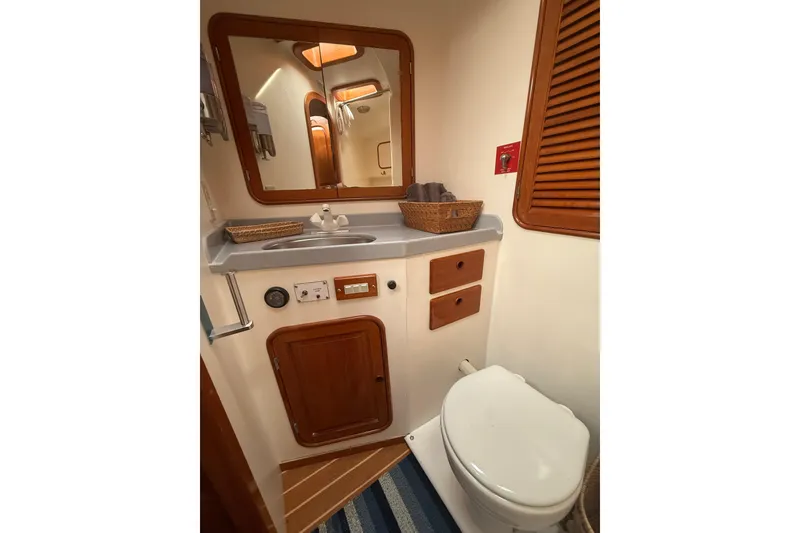 Slide: The Image of 1989 Nordhavn 46 yacht bathroom with wooden accents, mirror, and compact design. - 24