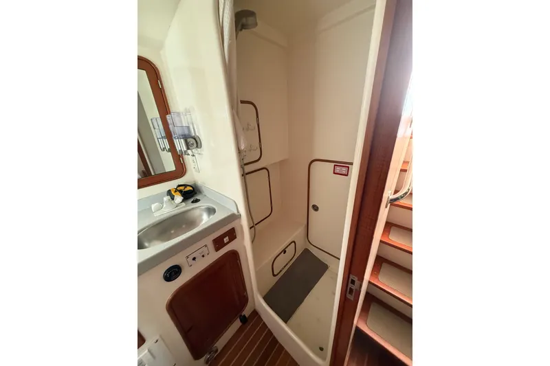 Slide: The Image of 1989 Nordhavn 46 yacht anchored near rocky coastline with kayak nearby. - 29