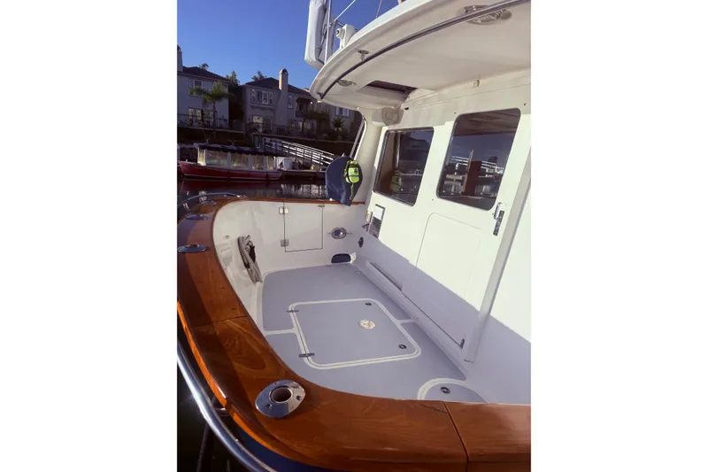 Slide: The Image of 1989 Nordhavn 46 yacht deck with wooden railings and white cabin door. - 8