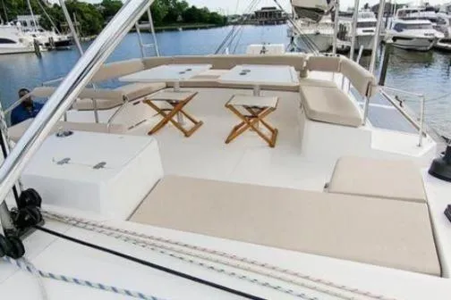 Slide: The Image of 2021 Bali 5.4 yacht deck with seating and tables, docked at a marina. - 17