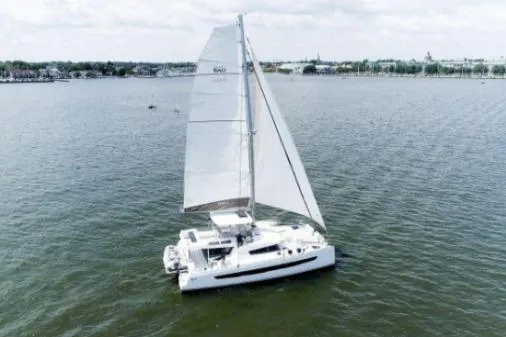 Slide: The Image of 2021 Bali 5.4 catamaran sailing on a calm lake under a cloudy sky. - 3