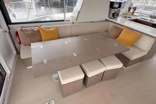 Slide: The Image of Modern Bali 5.4 yacht interior with dining area, beige seating, and yellow cushions, 2021 model. - 4