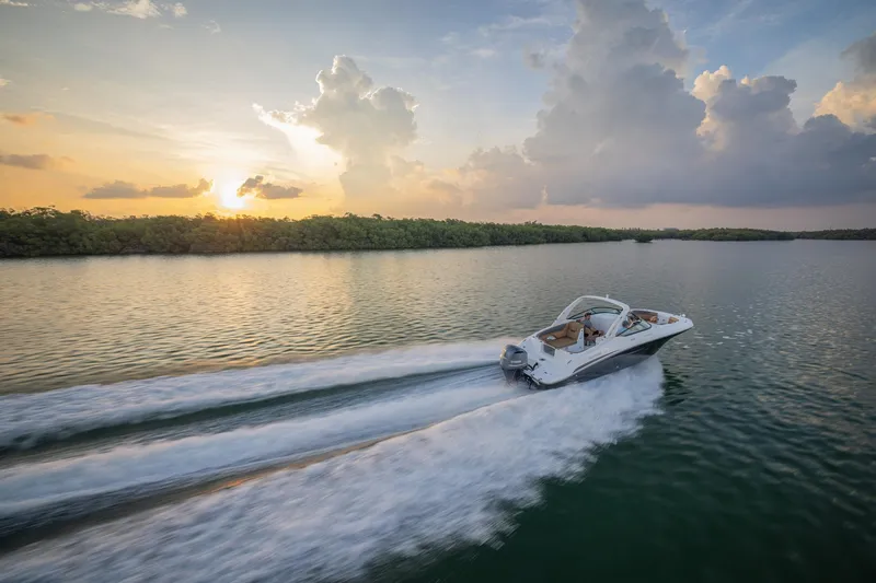 Slide: The Image of 2026 Hurricane SunDeck 2690 OB cruising on serene water at sunset. - 21