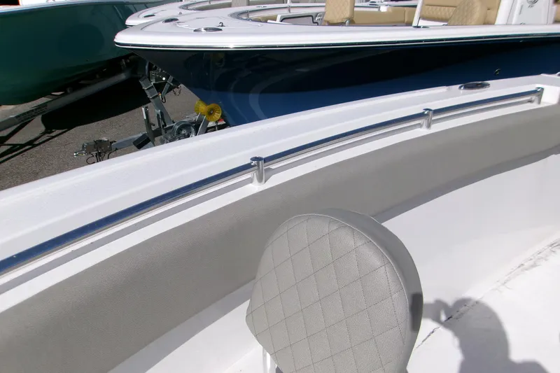 Slide: The Image of 2025 Sportsman Open 252 Center Console boat interior with cushioned seating and stainless steel railing. - 11