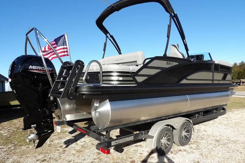 Slide: The Image of 2026 Bennington M Swingback 22 MSB pontoon boat on trailer, featuring Mercury outboard motor. - 7