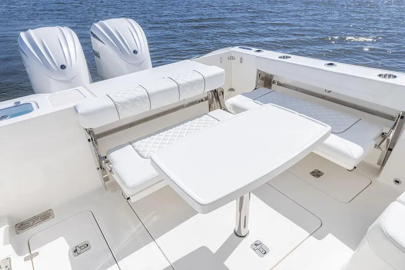 Slide: The Image of Manufacturer Provided Image: 2025 Pursuit DC 306 Dual Console boat interior with seating and table on the water. - 14