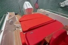 Slide: The Image of Red seating on 2021 Nimbus T8 boat with water backdrop. - 26