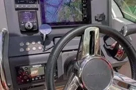 Slide: The Image of 2021 Nimbus T8 boat with red seating, docked in clear water. - 36