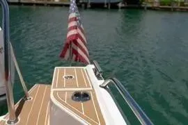 Slide: The Image of 2021 Nimbus T8 boat on water with American flag, surrounded by tropical scenery. - 43