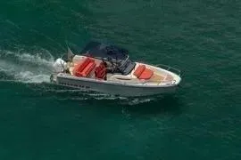 Slide: The Image of Nimbus T8 2021 motorboat cruising on clear green water, featuring red seating and canopy. - 5