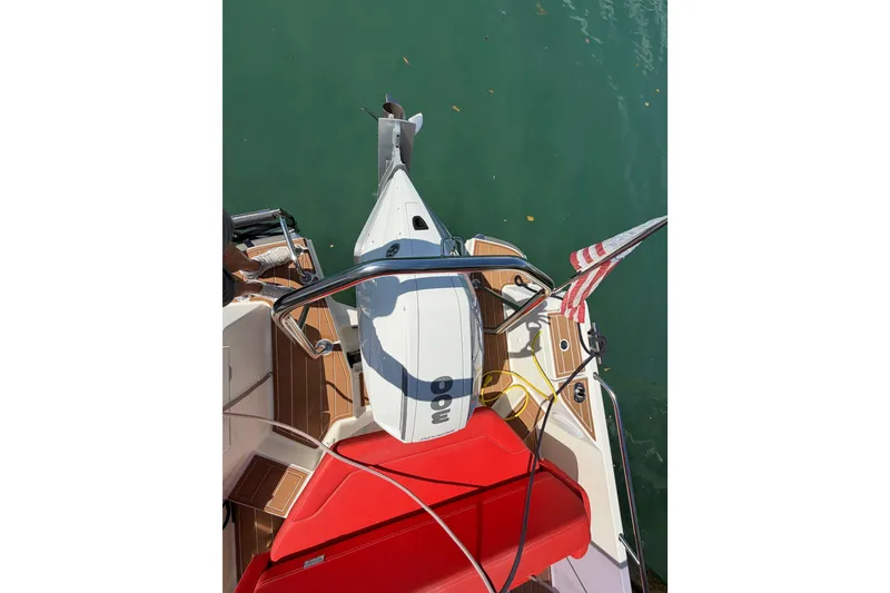 Slide: The Image of 2021 Nimbus T8 boat with red seating and American flag, docked on calm water. - 54