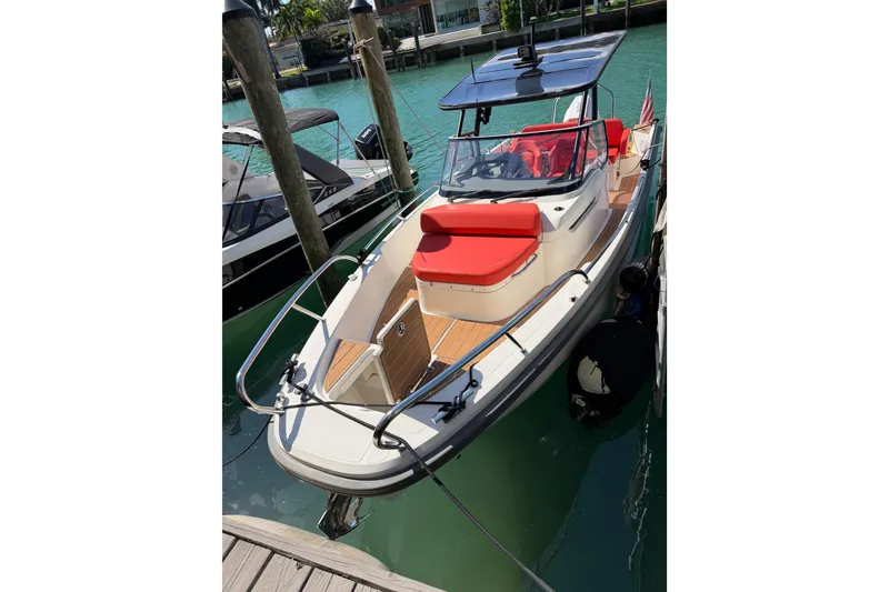 Slide: The Image of 2021 Nimbus T8 boat docked, featuring red seating and sleek design. - 60