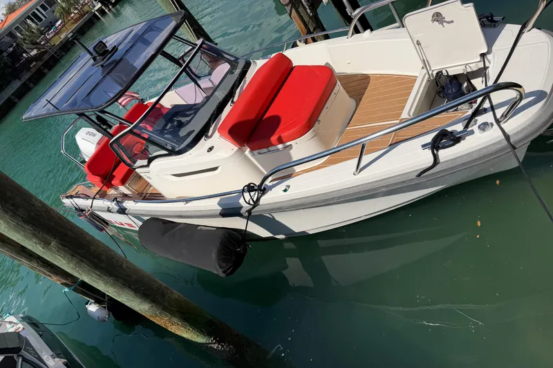 Slide: The Image of 2021 Nimbus T8 boat with red seating, docked in clear turquoise water. - 61