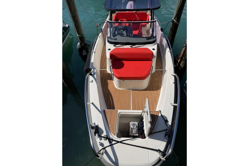 Slide: The Image of Nimbus T8 2021 boat with red seating and wooden deck, docked at marina. - 62