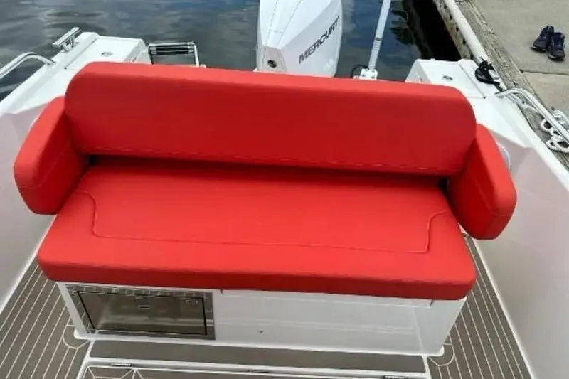 Slide: The Image of 2021 Nimbus T8 boat with red seating, docked by the water. - 9