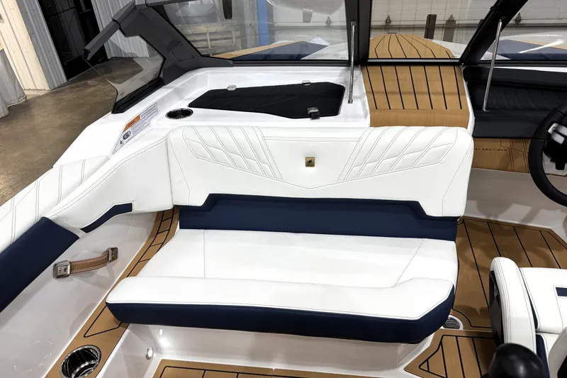 Slide: The Image of 2026 Nautique Ski Nautique interior with white and navy seating, wood accents, and modern design. - 13