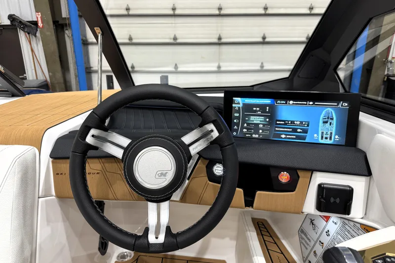 Slide: The Image of 2026 Nautique Ski Nautique dashboard with steering wheel and digital display in a modern boat interior. - 18