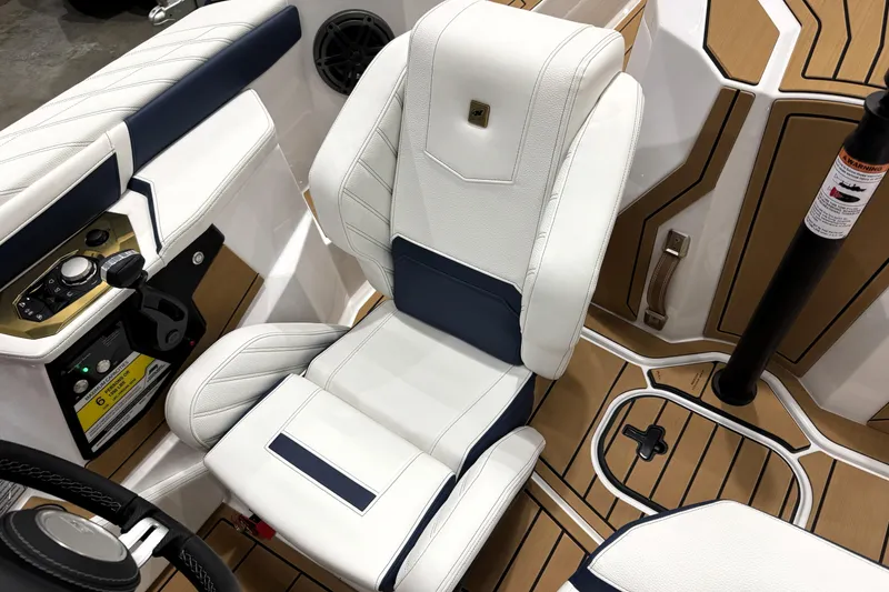 Slide: The Image of 2026 Nautique Ski Nautique interior with white and navy seating, modern controls, and teak flooring. - 21