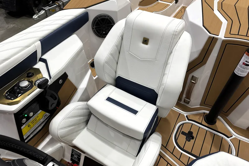 Slide: The Image of 2026 Nautique Ski Nautique interior with white and navy seating, modern controls, and teak flooring. - 22