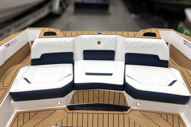 Slide: The Image of 2026 Nautique Ski Nautique boat interior with white and navy seating, teak flooring. - 7