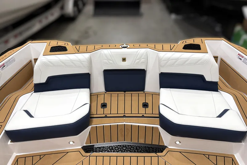 Slide: The Image of 2026 Nautique Ski Nautique boat interior with white and navy seating, teak flooring. - 8