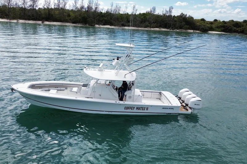 The Image of 2018 Regulator 41 boat on calm water, featuring triple Yamaha engines. - 0