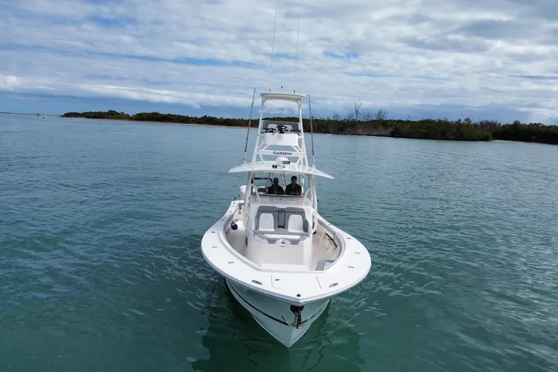 Slide: The Image of 2018 Regulator 41 boat on calm water with distant shoreline and cloudy sky. - 15
