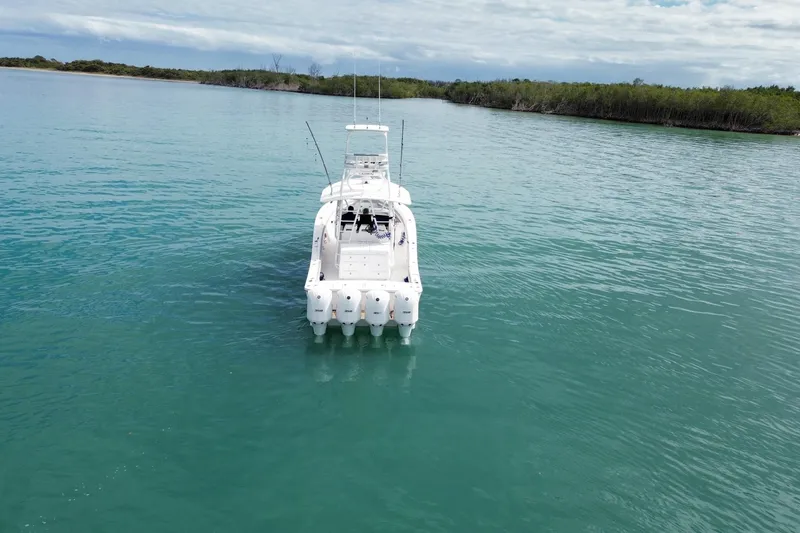 Slide: The Image of 2018 Regulator 41 boat on calm turquoise water, surrounded by lush greenery. - 7